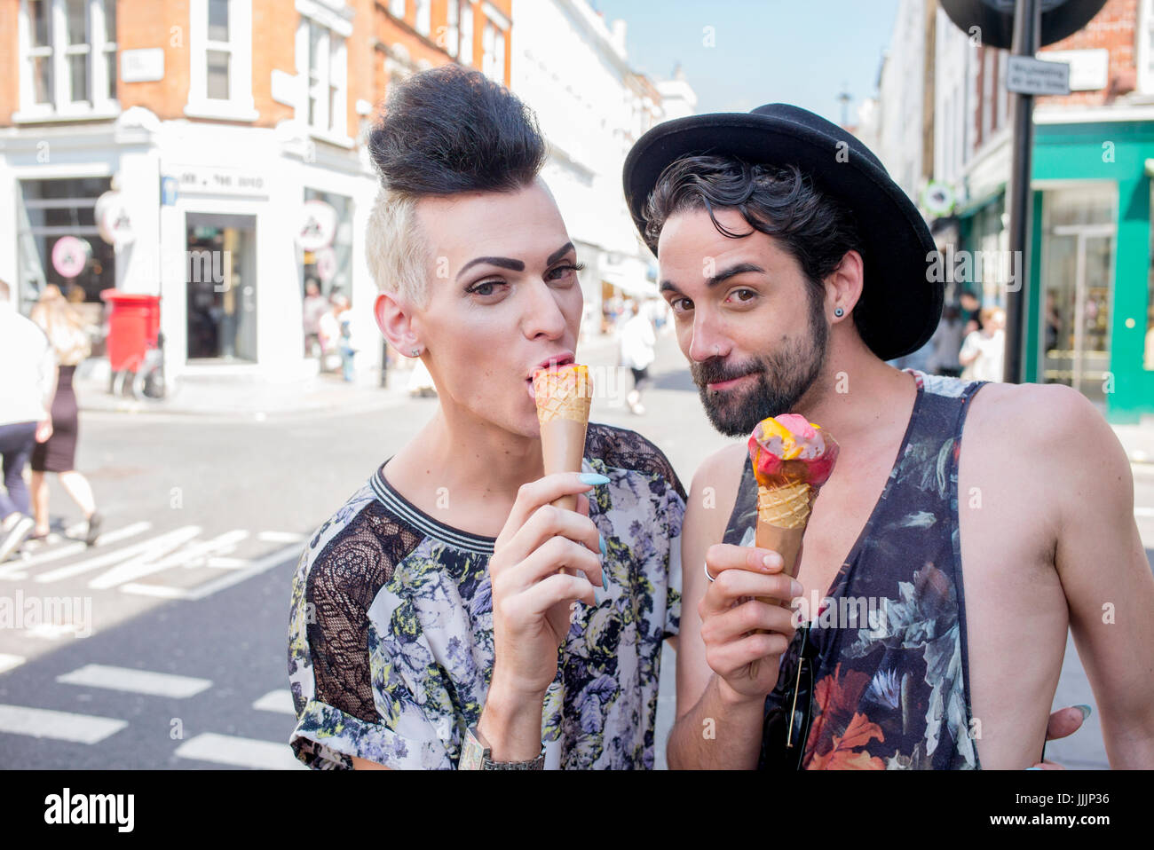 Una coppia gay gustare un gelato in una giornata fuori a Londra. Foto Stock