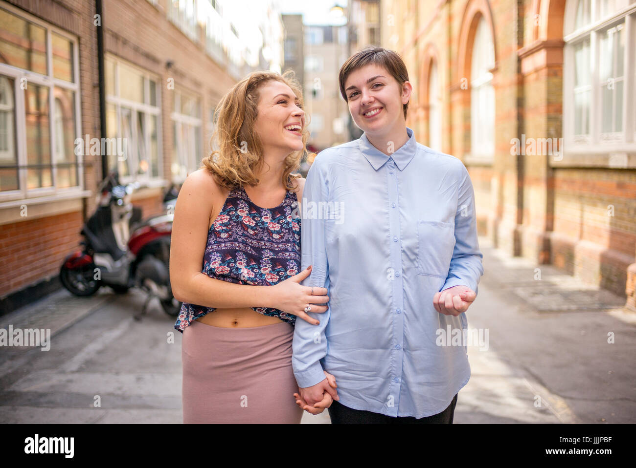 Una giovane coppia lesbica a piedi lungo la strada insieme. Foto Stock