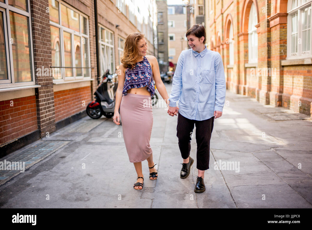 Una giovane coppia lesbica a piedi lungo la strada insieme. Foto Stock
