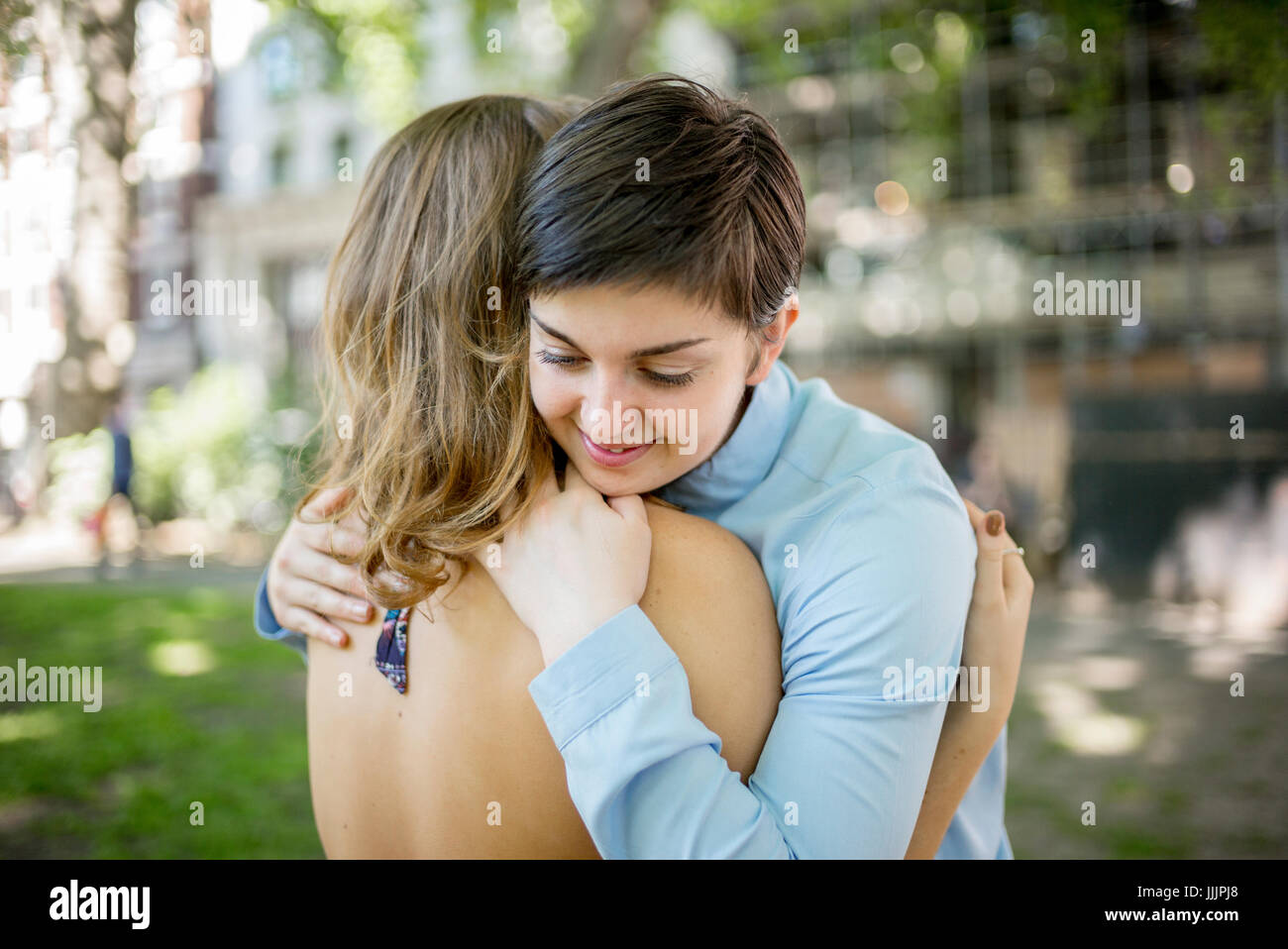 Una giovane coppia lesbica abbracciarsi nel parco. Foto Stock