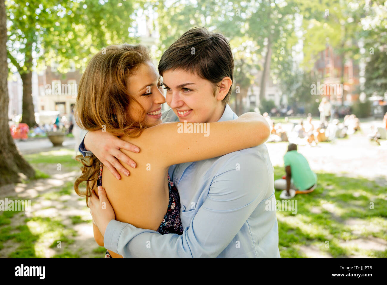 Una giovane coppia lesbica abbracciarsi nel parco. Foto Stock