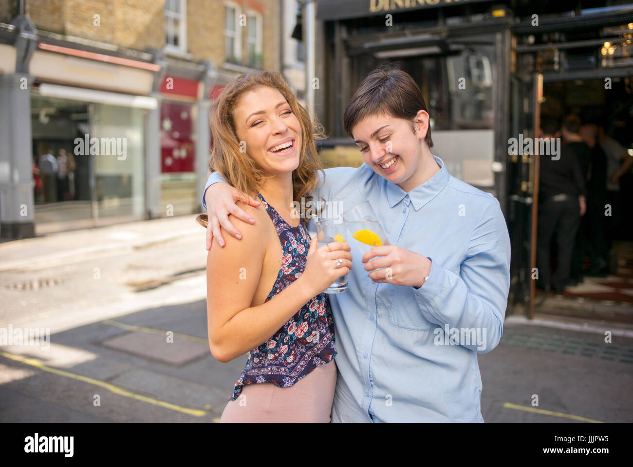 Una giovane coppia lesbica godetevi un drink al sole. Foto Stock