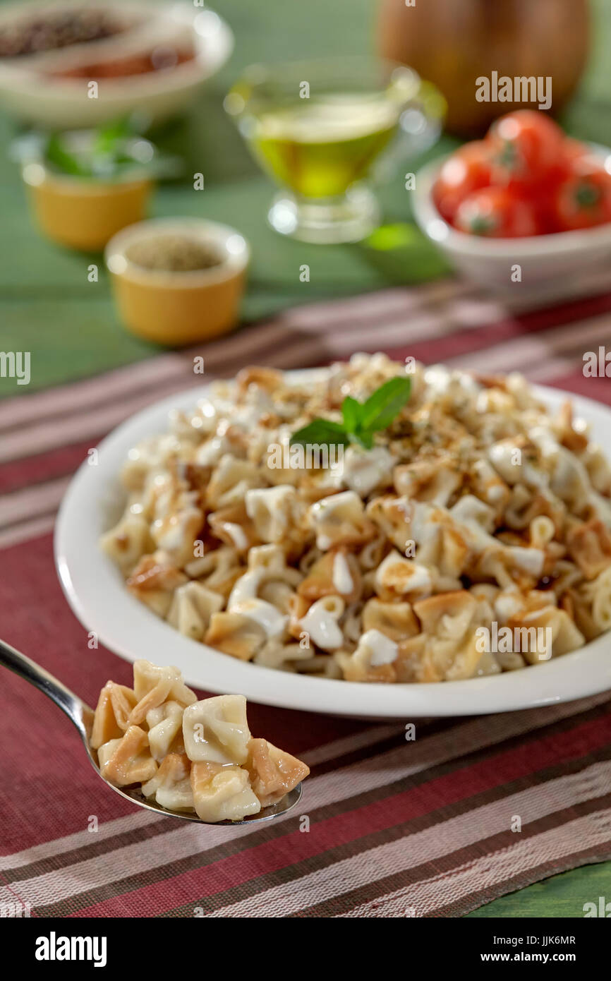 Manti,bagno turco Manti manlama sulla piastra con il peperone rosso, il sugo di pomodoro, yogurt e menta Foto Stock