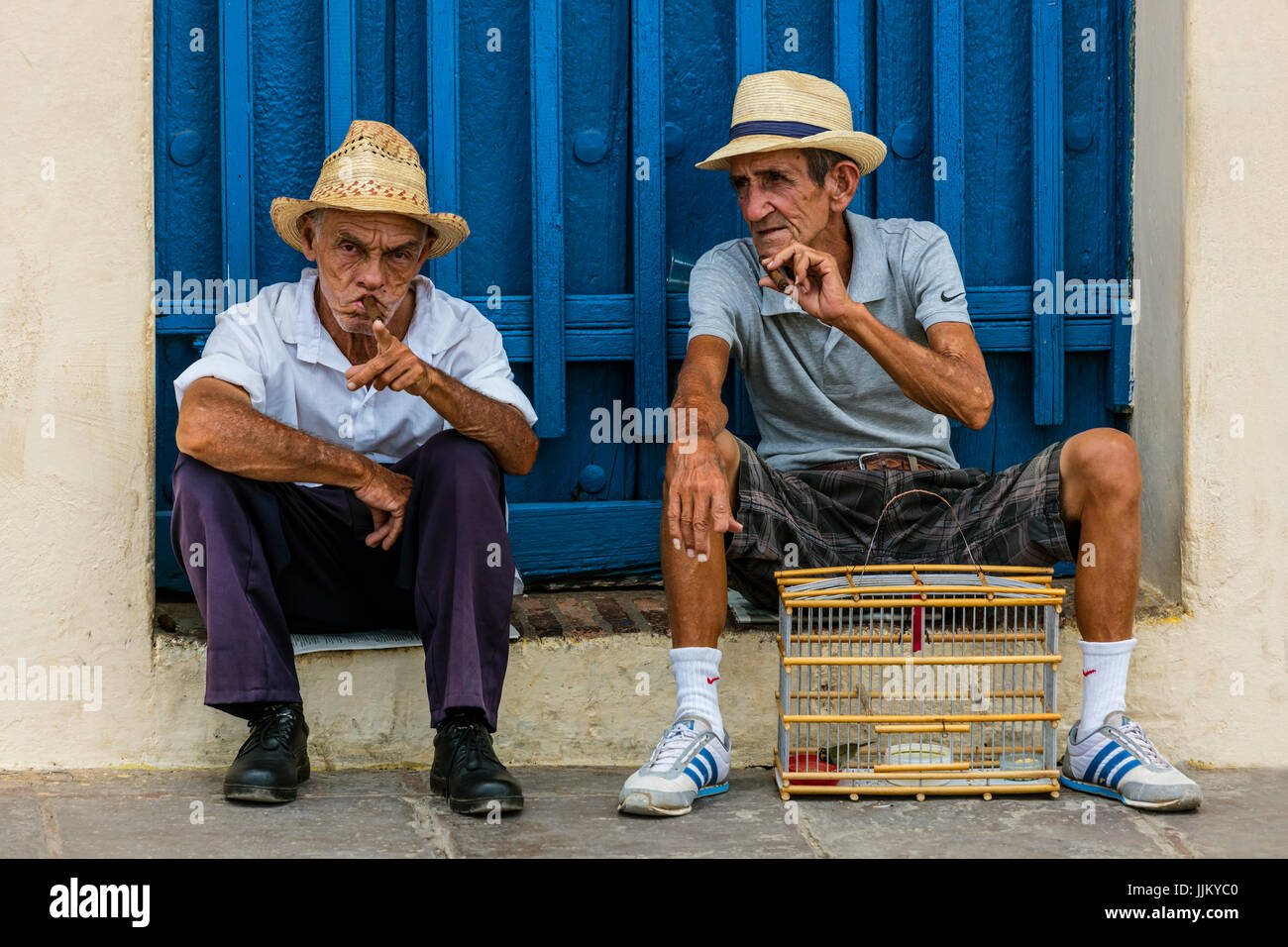 I vecchi cubani, uomini fumatori di sigari in PLAZA MAYOR - Trinidad, Cuba Foto Stock