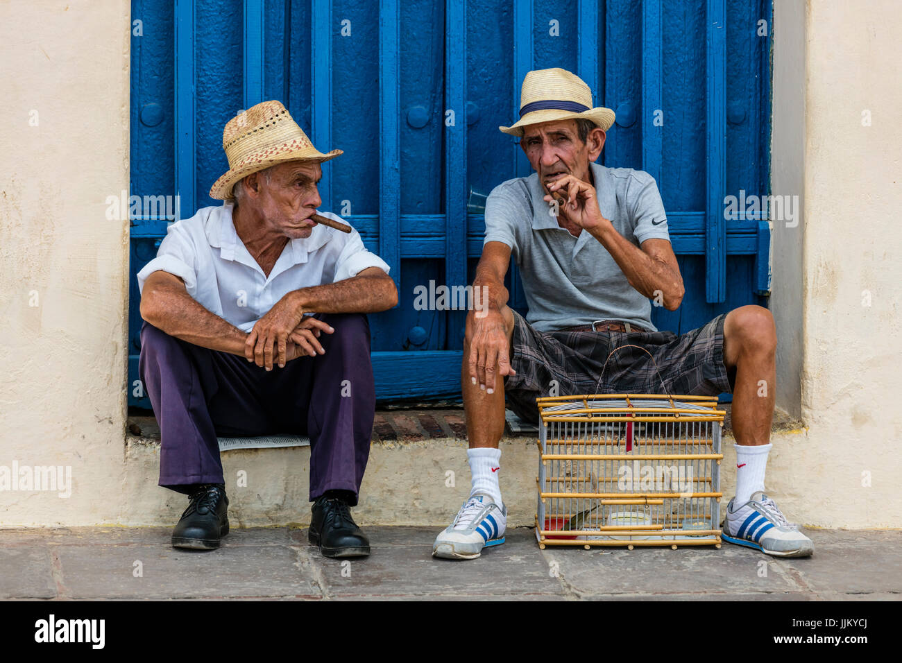 I vecchi cubani, uomini fumatori di sigari in PLAZA MAYOR - Trinidad, Cuba Foto Stock