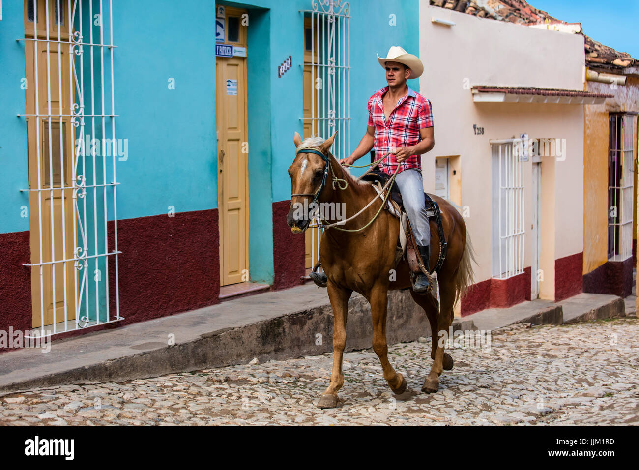 Cavalli e cowboy sono un sito comune sulle strade lastricate di Trinidad, Cuba Foto Stock