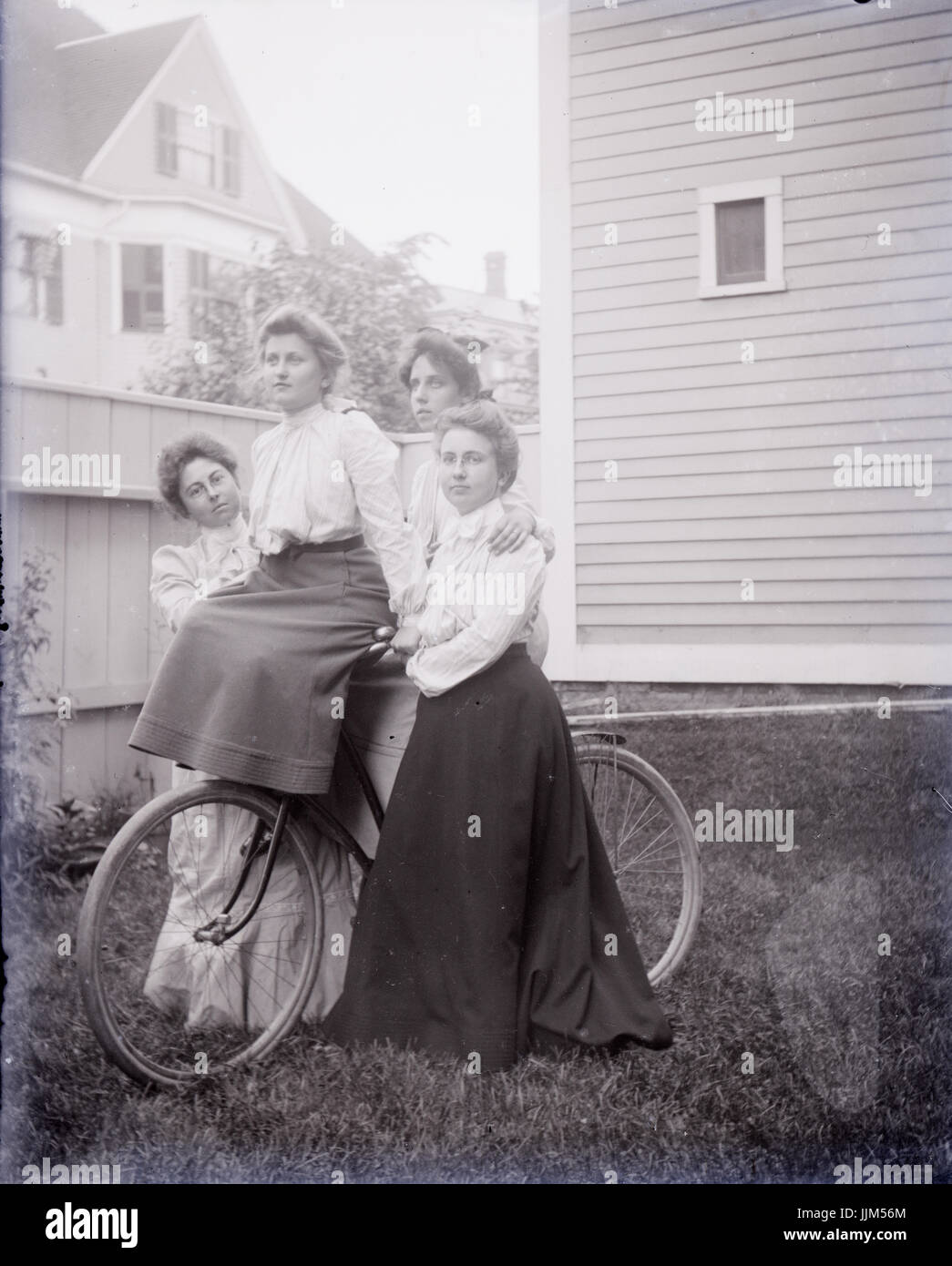 Antique c1910 fotografia, quattro donne su un antico bicicletta. Posizione sconosciuta, eventualmente Rhode Island, Stati Uniti d'America. Fonte: fotografia originale. Foto Stock