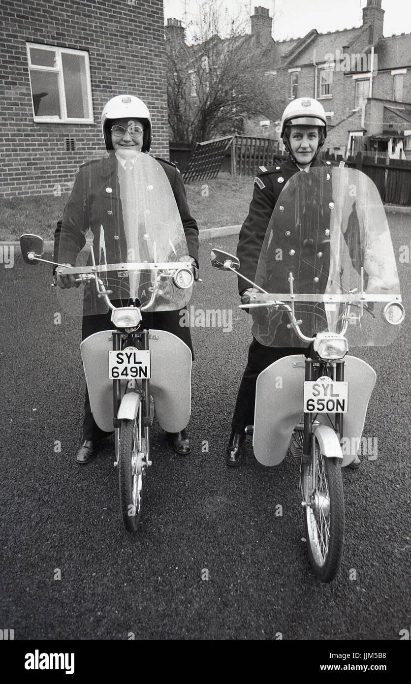 1974, Londra Sud, due femmine operai del traffico sul loro nuovo modo di trasporto per la loro applicazione della legge il lavoro, piccolo agile mopedswith visiere di plastica e fariings. Foto Stock