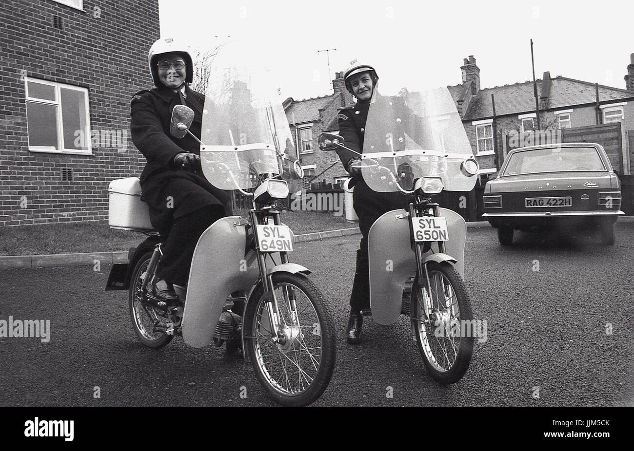 1974, Londra Sud, due femmine operai del traffico sul loro nuovo modo di trasporto per la loro applicazione della legge il lavoro, piccolo agile mopedswith visiere di plastica e fariings. Foto Stock