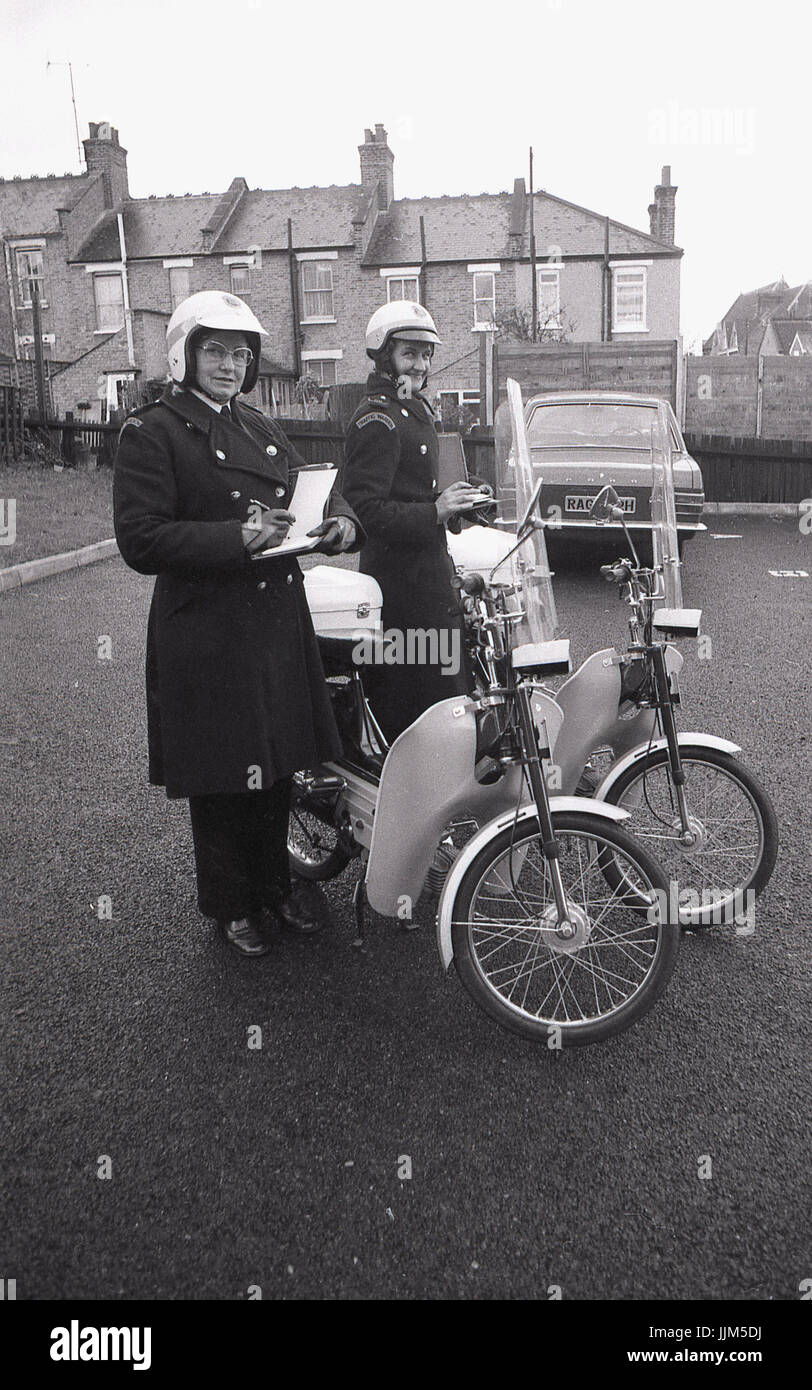 1974, Londra Sud, due traffico femmina operai fuori di pattuglia con i loro libri di biglietteria e del loro nuovo modo di trasporto per la loro applicazione della legge il lavoro, piccolo agile mopedswith visiere di plastica e fariings. Foto Stock