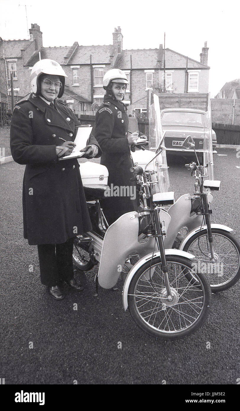 1974, Londra Sud, due femmine operai del traffico con i loro libri di biglietteria e del loro nuovo modo di trasporto per la loro applicazione della legge il lavoro, piccole agili per i ciclomotori muniti di visiere di plastica e fariings. Foto Stock