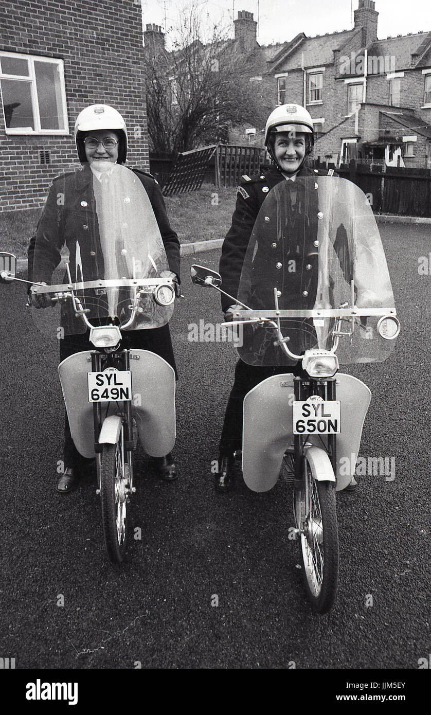 1974, Londra Sud, due femmine operai del traffico sul loro nuovo modo di trasporto per la loro applicazione della legge il lavoro, piccole agili per i ciclomotori muniti di visiere di plastica e fariings. Foto Stock