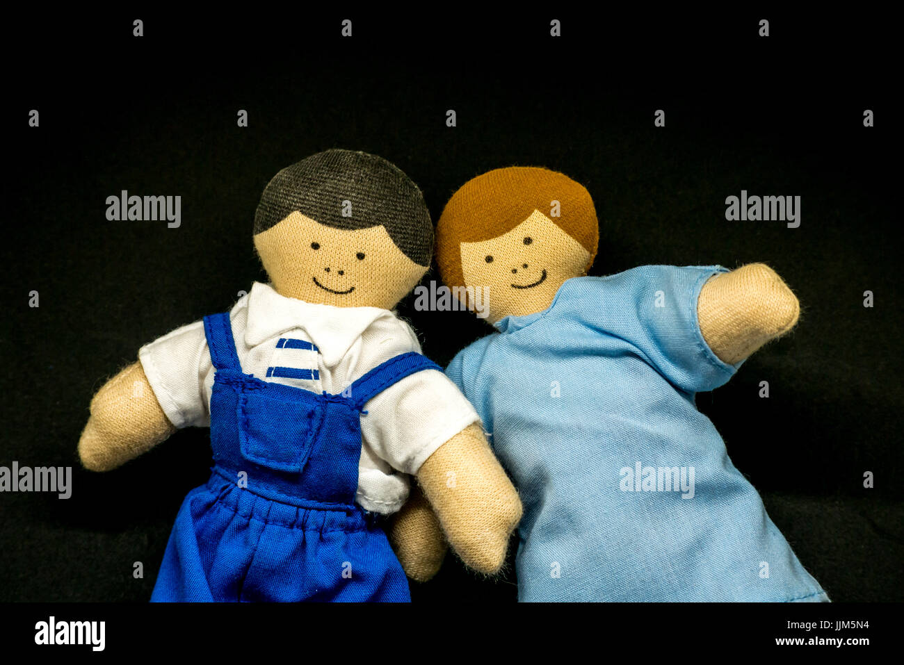 Ancora in vita del maschio e femmina bambole giocattolo contro lo sfondo nero per rappresentare i genitori, giovane, i membri della famiglia, relazioni, matrimonio e generi Foto Stock