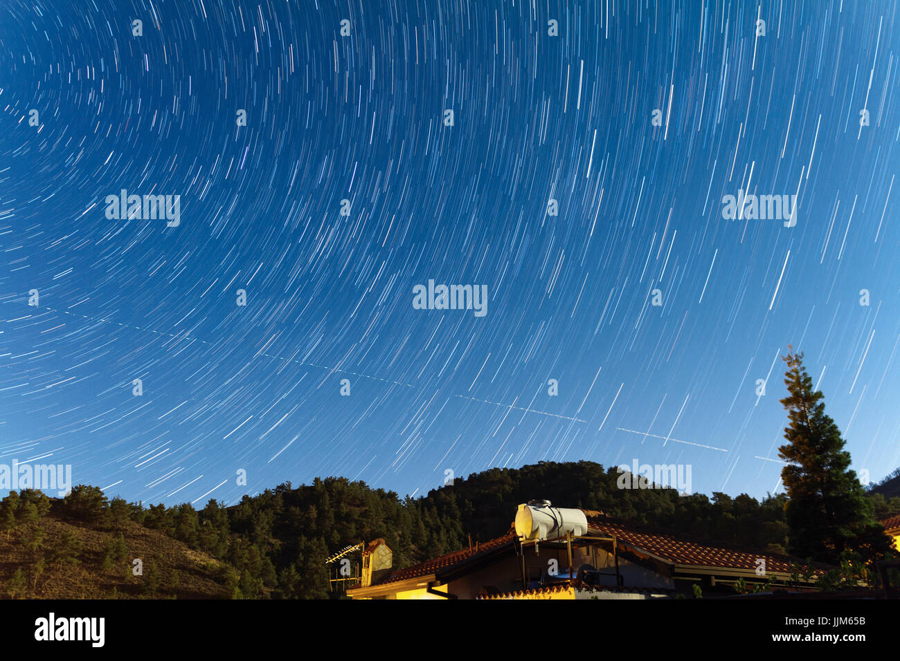 Tracce stellari nel corso di una casa presso i monti Troodos come due aeroplani travers il cielo. Acquisiti nel villaggio di Kakopetria in Cipro Foto Stock