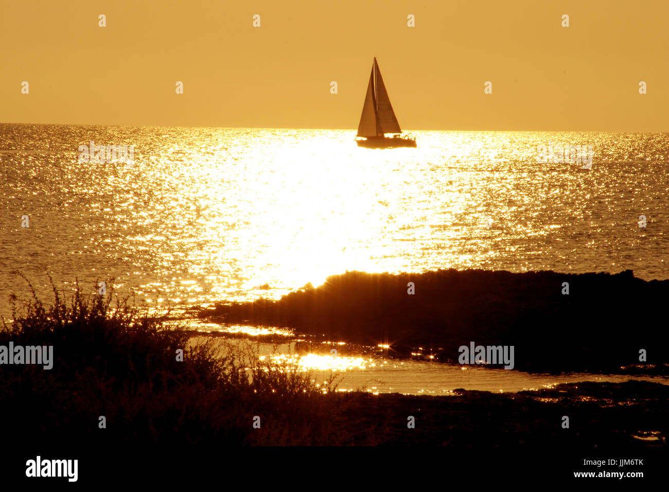 Barca a vela al tramonto Foto Stock