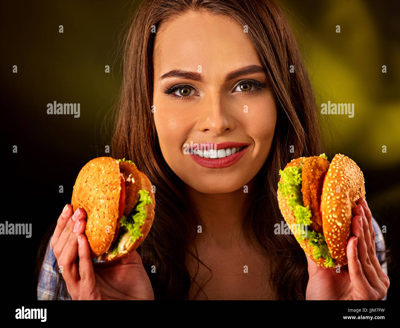 Donna di mangiare hamburger. Ragazza morso del grande burger Foto Stock