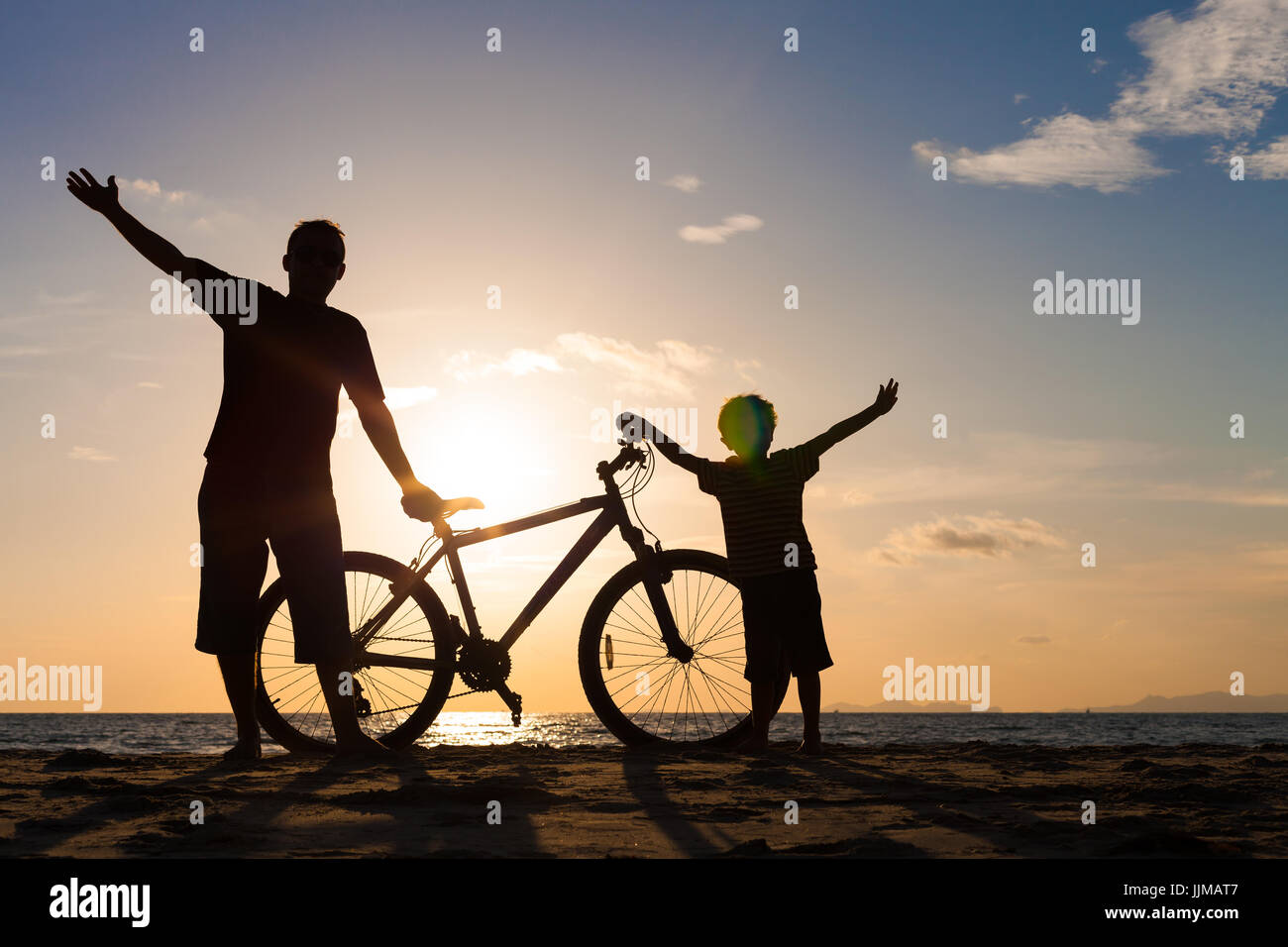 Padre e figlio giocando sulla spiaggia al tramonto. Concetto di felice famiglia amichevole. Foto Stock
