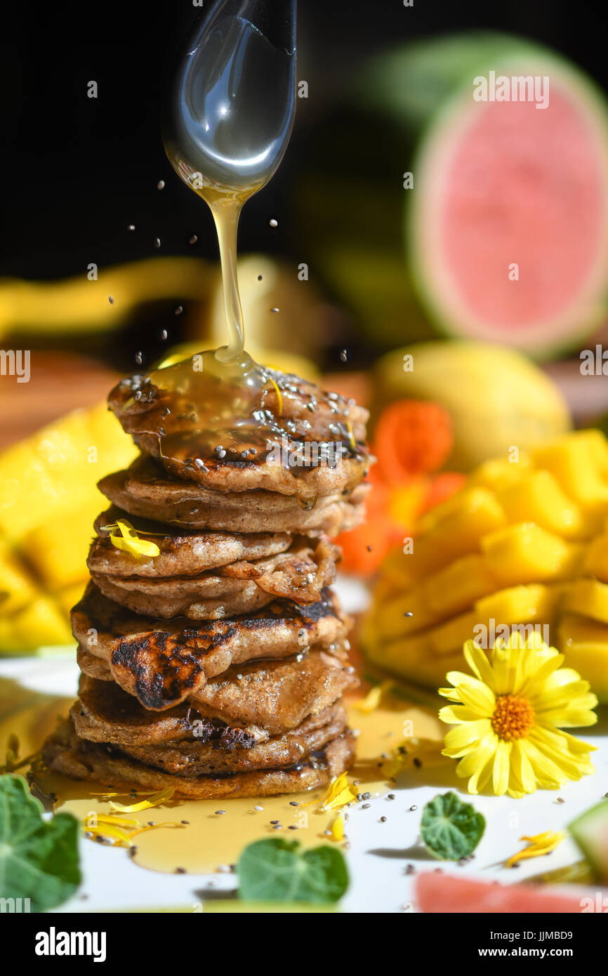 Vegan senza glutine frittelle con sciroppo di gocciolare all e seme di essere spruzzata sulla pila corta. Foto Stock