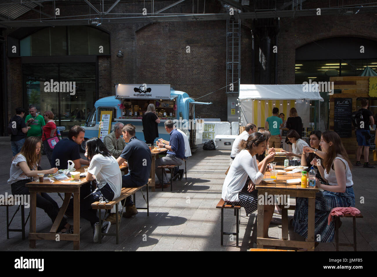 La tettoia mercato, King's Cross. I giovani di mangiare cibo di strada Foto Stock