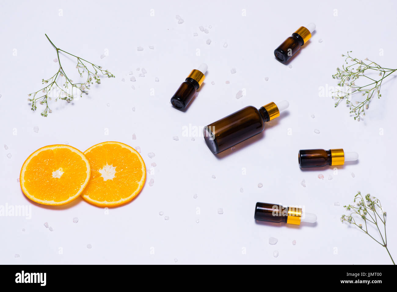 Il Branding mock-up. Olio essenziale naturale, bottiglia di cosmetici contenitori con fettine di arancia. Foto Stock