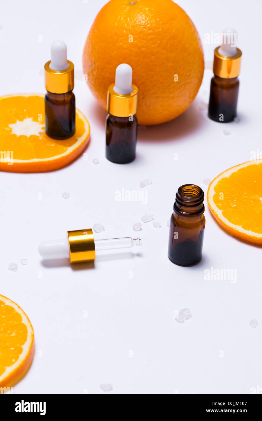 Il Branding mock-up. Olio essenziale naturale, bottiglia di cosmetici contenitori con fettine di arancia. Foto Stock