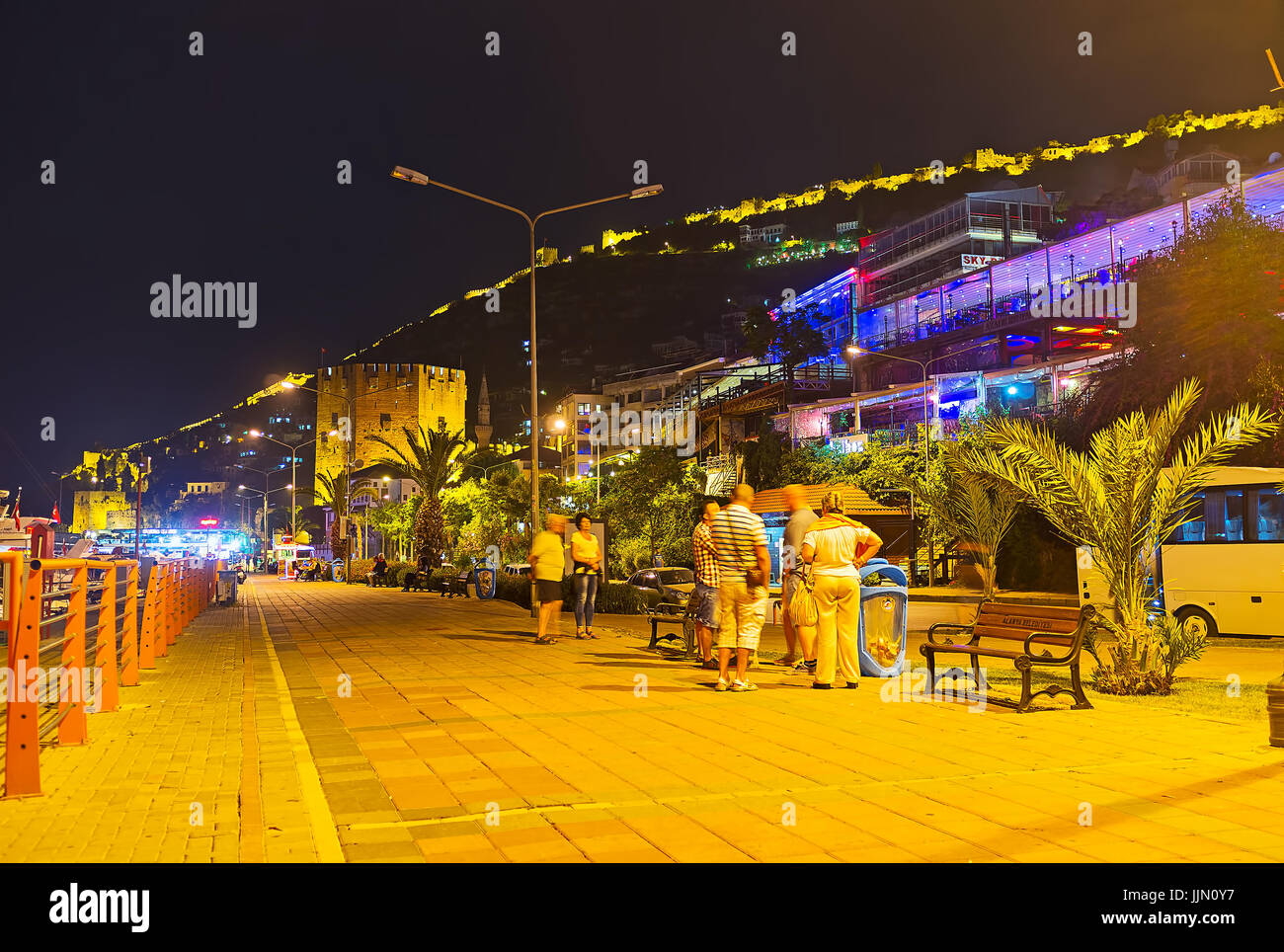 ALANYA, Turchia - 8 Maggio 2017: il turista a godere la notte Rihtim promenade, il luogo perfetto per guardare la cittadella illuminata mura sulla cima di una collina e t Foto Stock