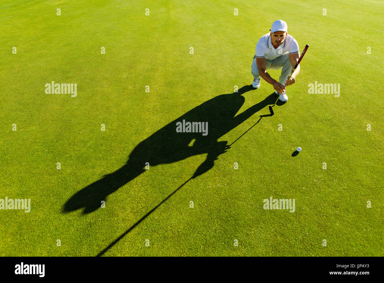 Giocatore di Golf Shot di puntamento con club in corso. Golfista maschio della linea di controllo per mettere la pallina da golf su erba verde. Foto Stock