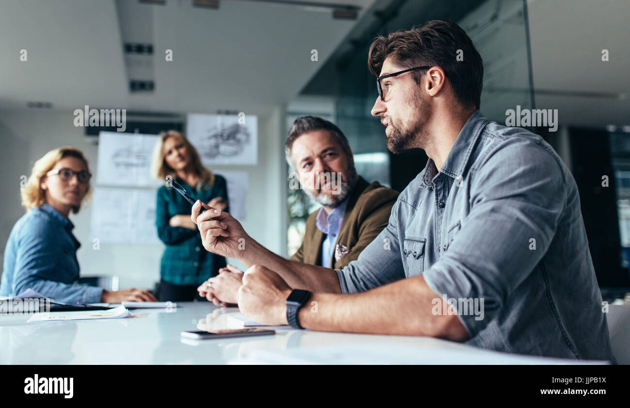I giovani designer dando alcune nuove idee sul progetto per il suo partner nella sala conferenze. La gente di affari a discutere su un nuovo progetto di business in ufficio. Foto Stock