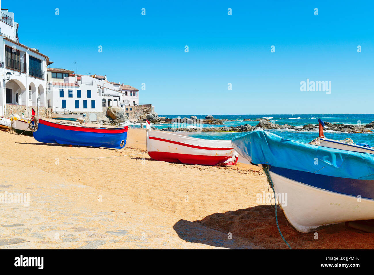 Alcune vecchie barche da pesca bloccati sulla spiaggia Barques in Calella de Palafrugell, Costa Brava Catalogna, con le sue caratteristiche case bianche wi Foto Stock