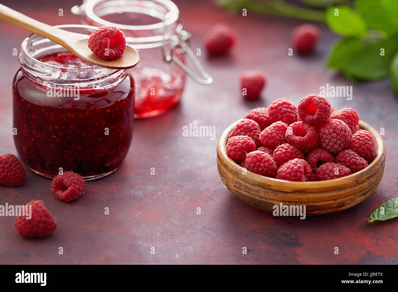 Lamponi freschi e un vasetto di marmellata di lamponi. Foto Stock