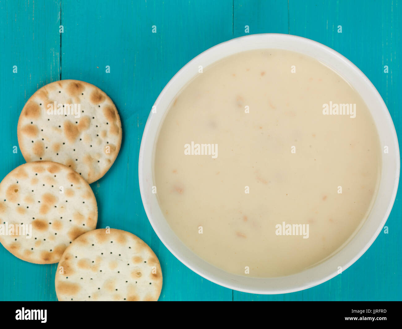 Ciotola di crema di zuppa di pollo contro uno sfondo blu Foto Stock