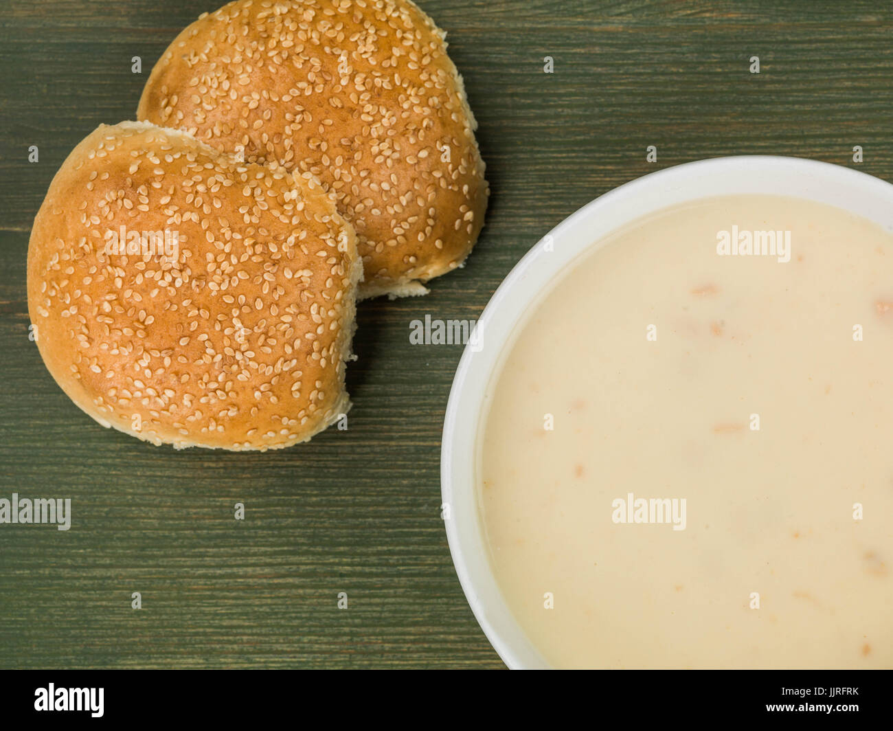 Ciotola di crema di zuppa di pollo con pane contro uno sfondo verde Foto Stock