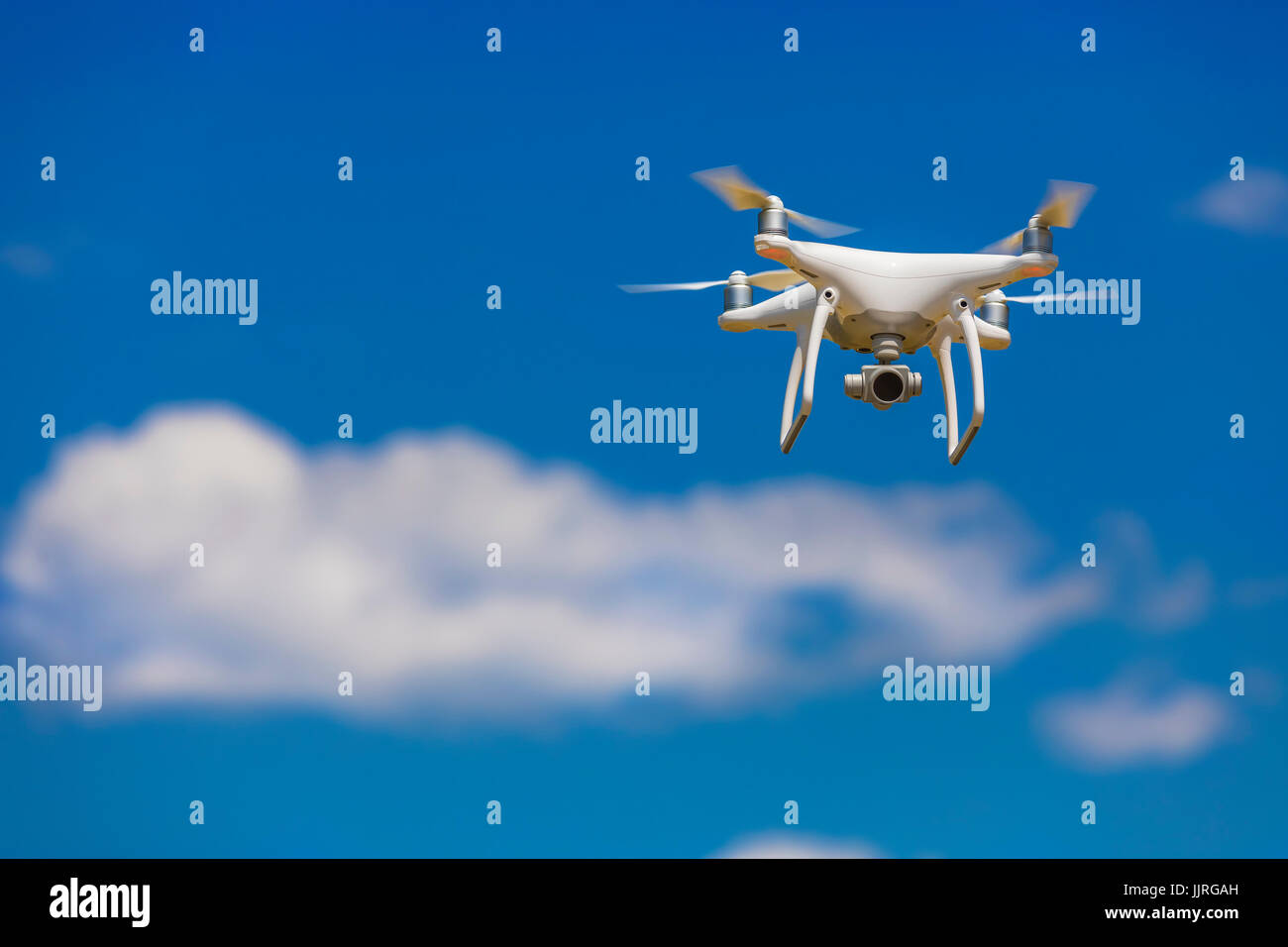 Telecamera professionale drone volare nel cielo blu chiaro parzialmente nuvoloso Foto Stock