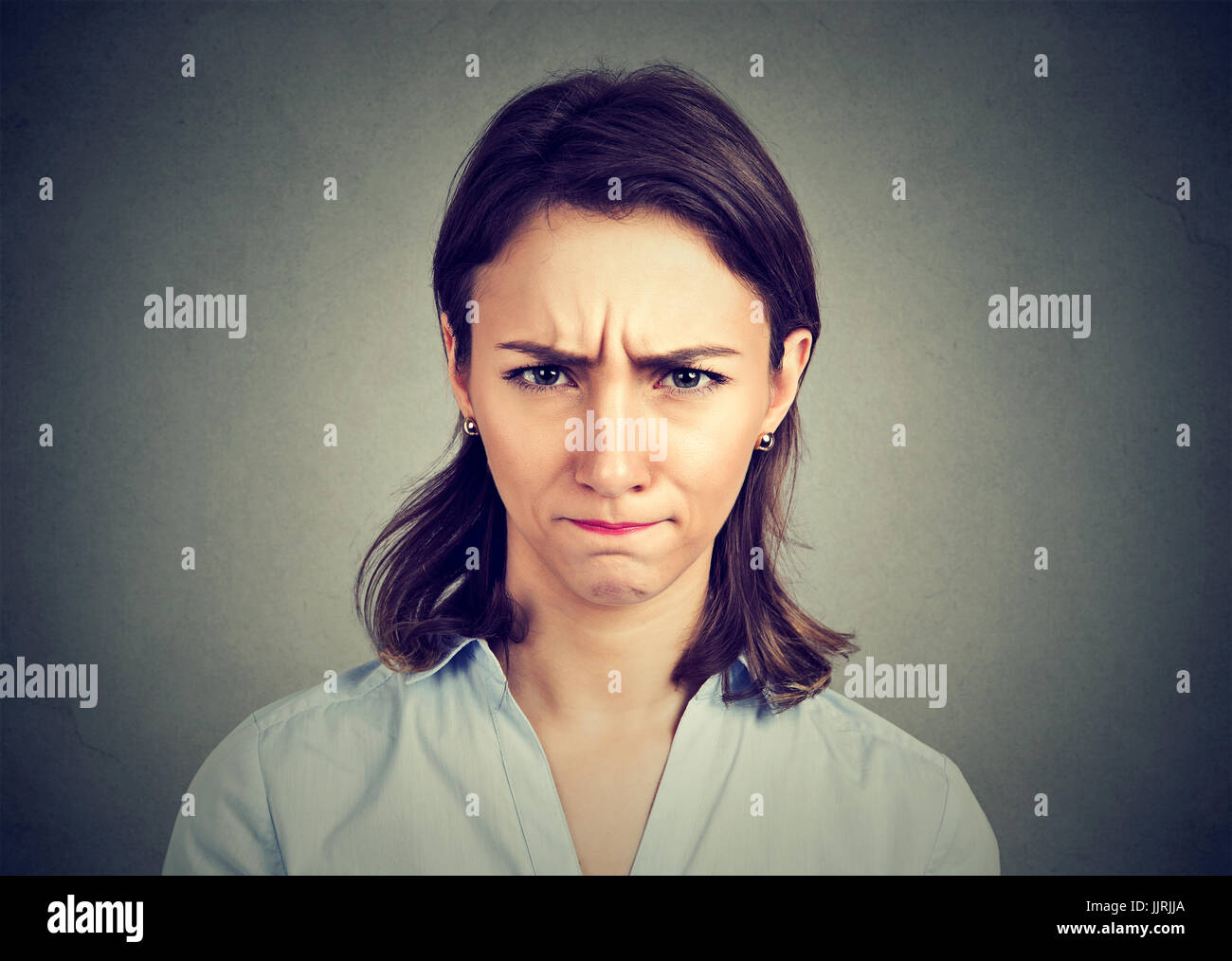 Arrabbiato giovane donna isolato su sfondo grigio. Negative le emozioni umane espressione facciale sentimenti Foto Stock