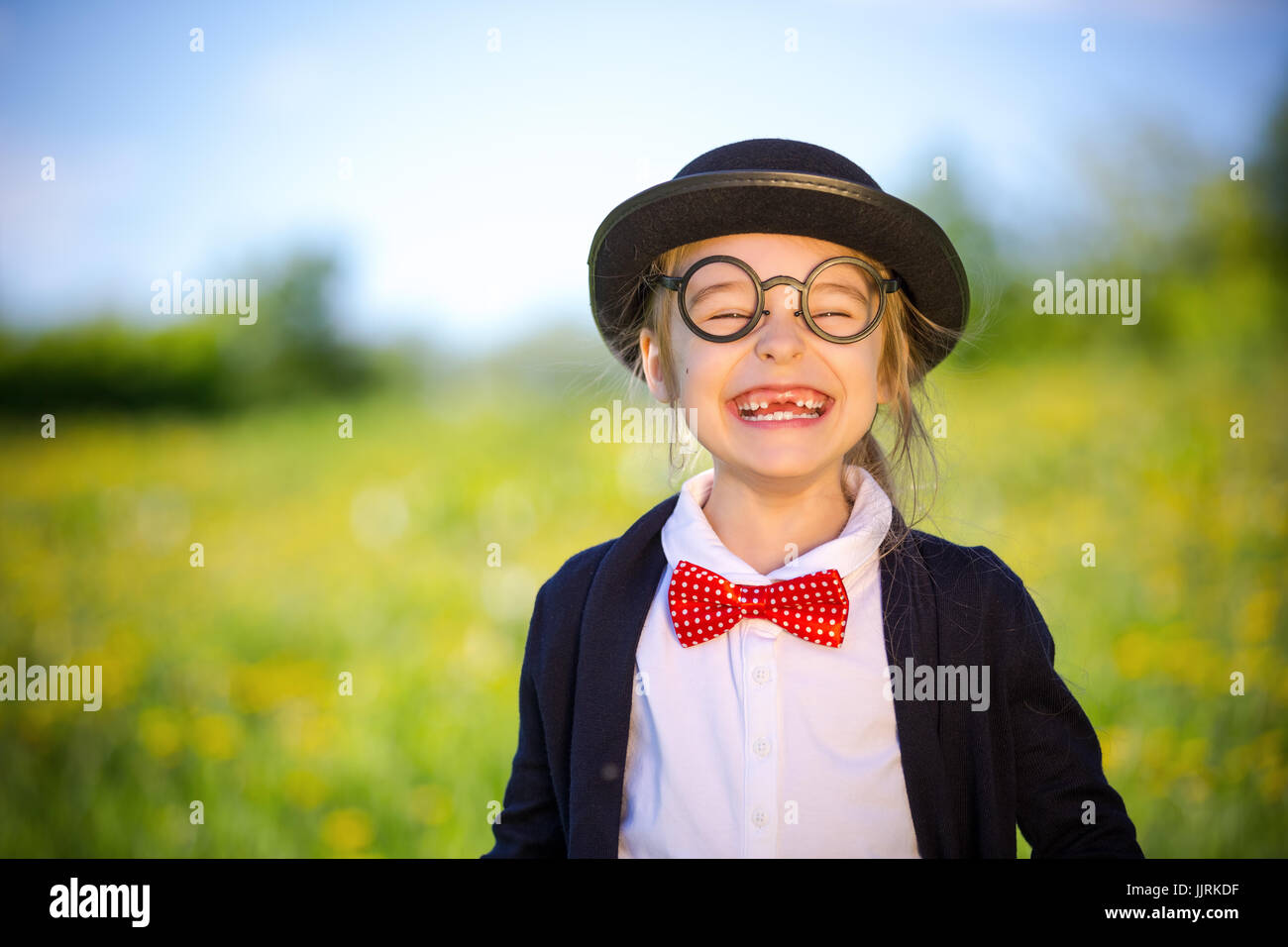 Funny felice bambina a bow tie e cappello bowler. Foto Stock