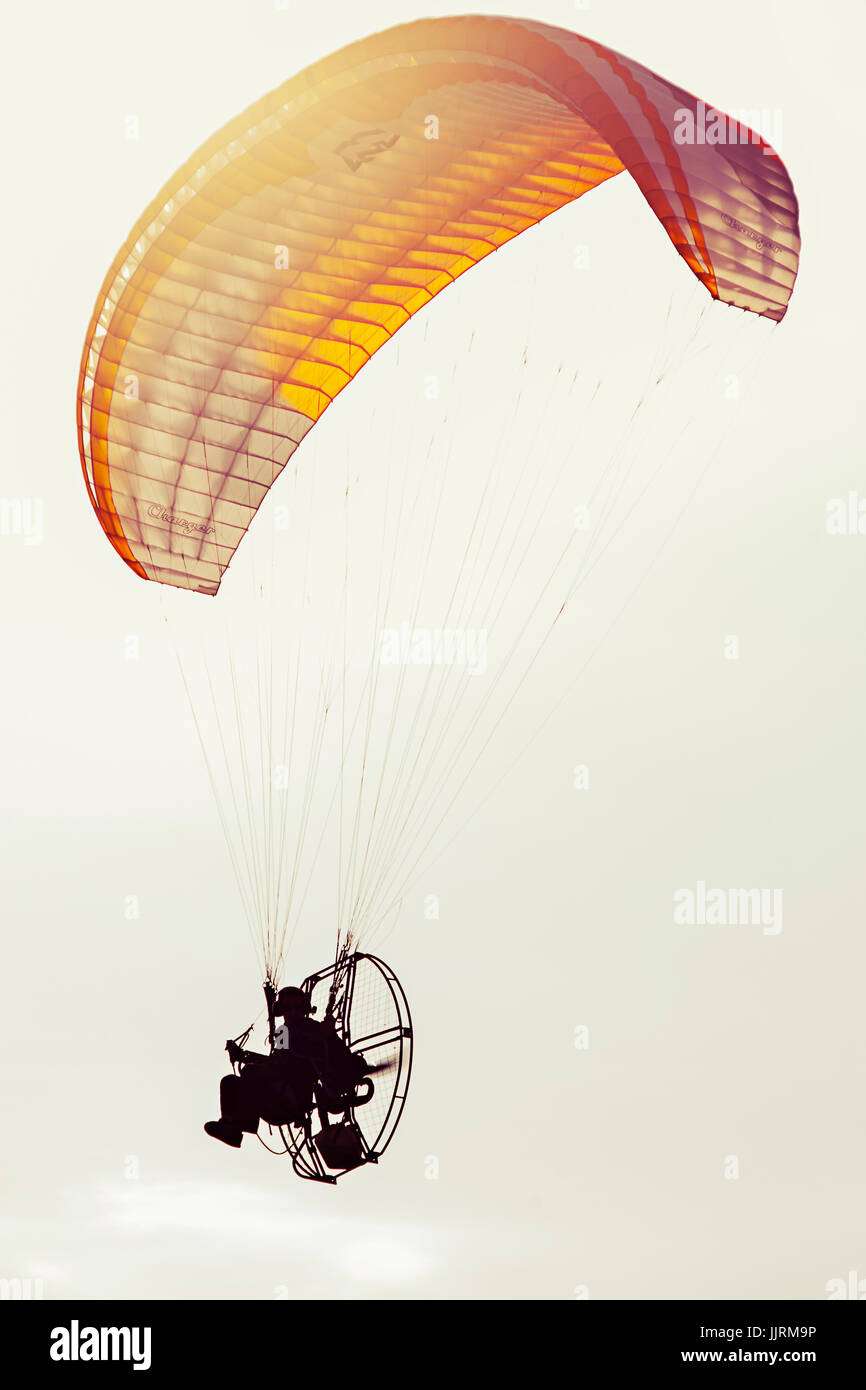 Parapendio volare il sovraccarico con la luce del sole che filtra attraverso il parafango. Foto Stock