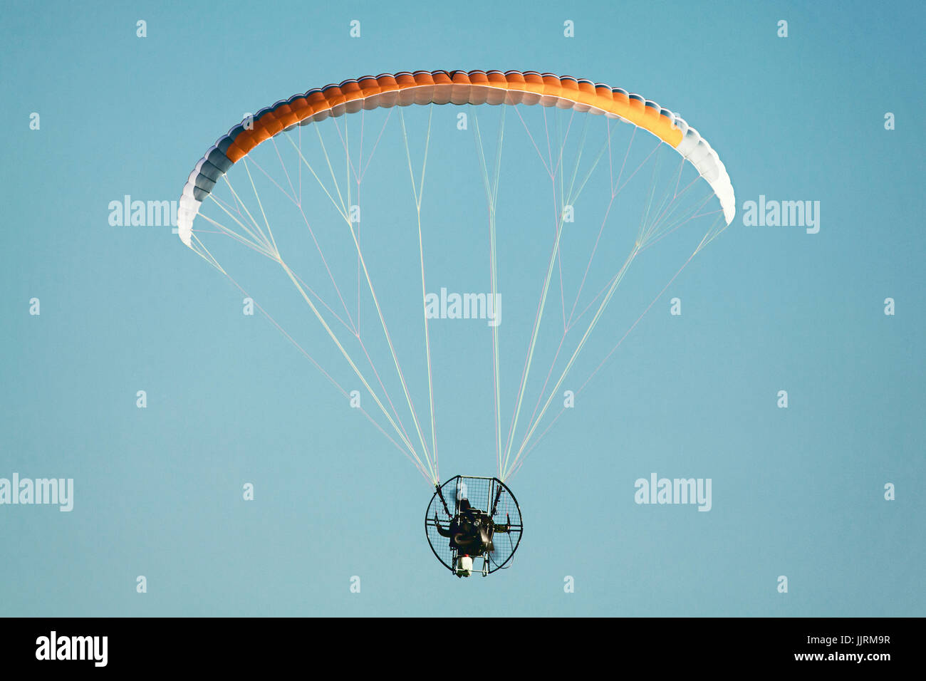 Powered parapendio volare contro un cielo blu chiaro. Foto Stock