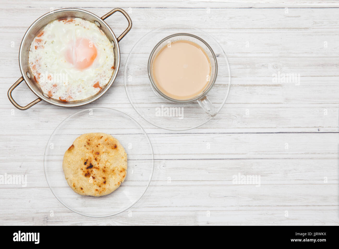 Uovo fritto, caffè e arepa su legno tavolo bianco Foto Stock