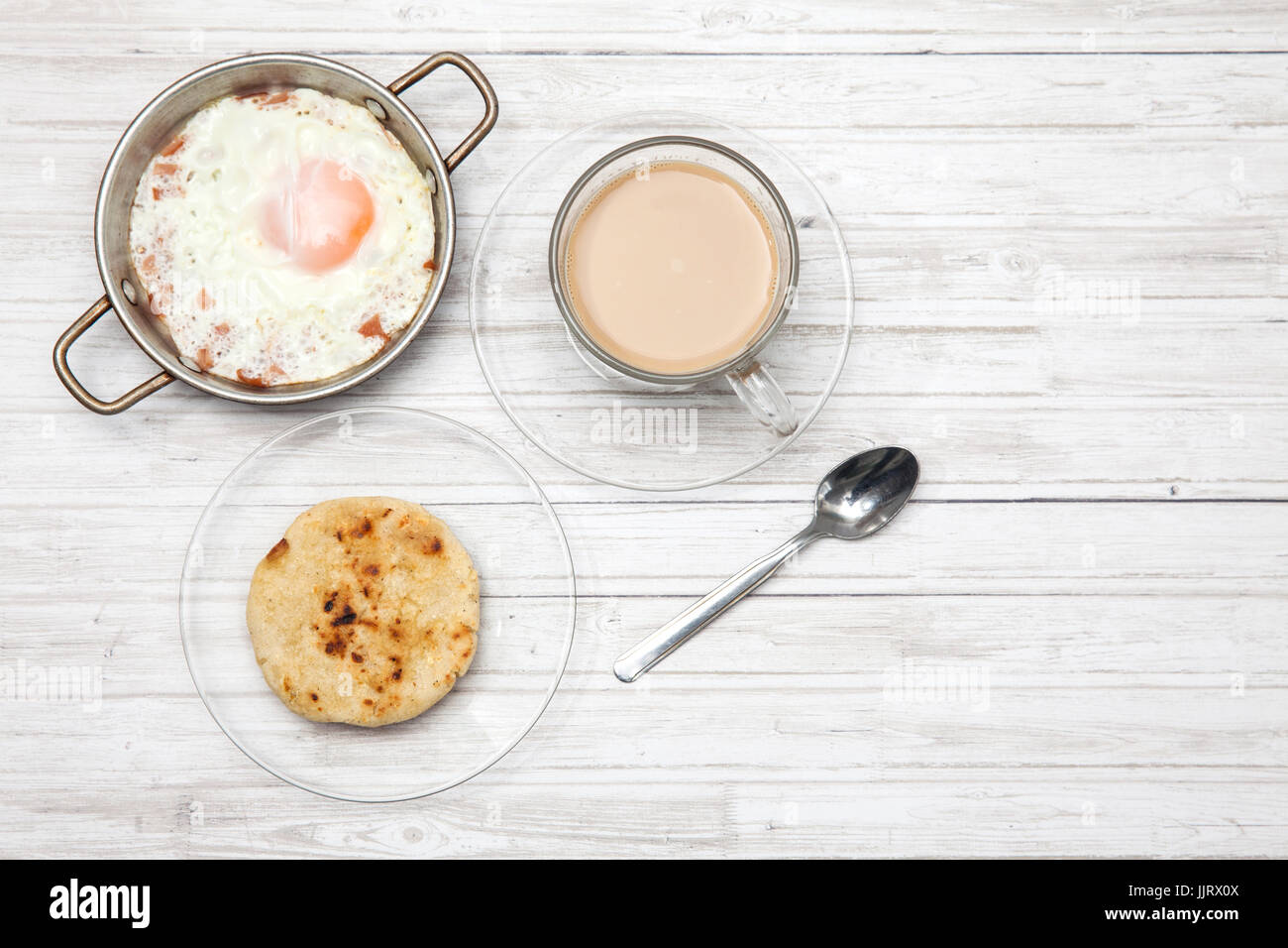 Uovo fritto, caffè e arepa su legno tavolo bianco Foto Stock