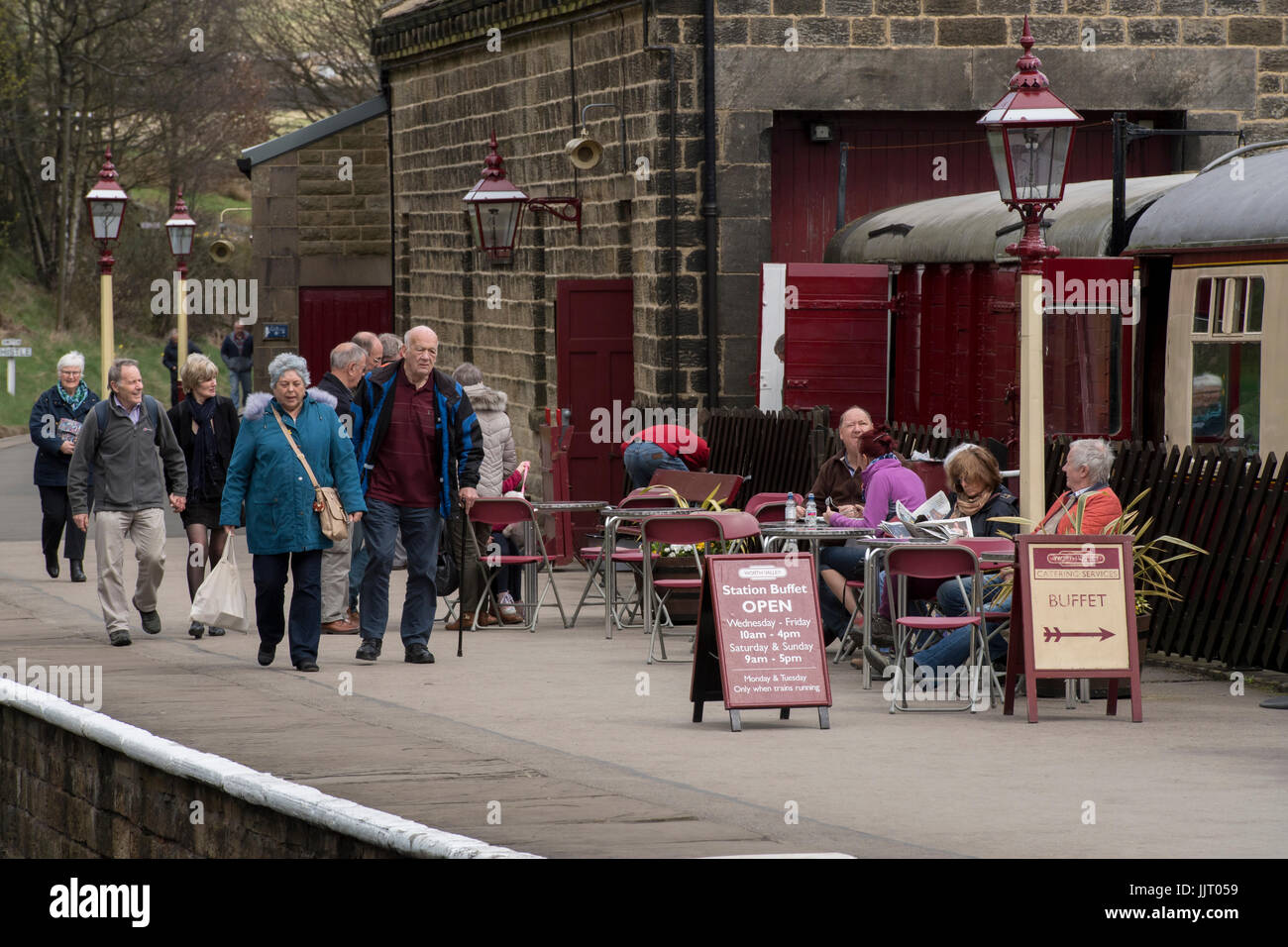 Le persone sulla piattaforma alla storica stazione Oxenhope, alcune passeggiate & alcuni relax al piccolo cafe - Keighley e Worth Valley Railway Station, Inghilterra, Regno Unito. Foto Stock