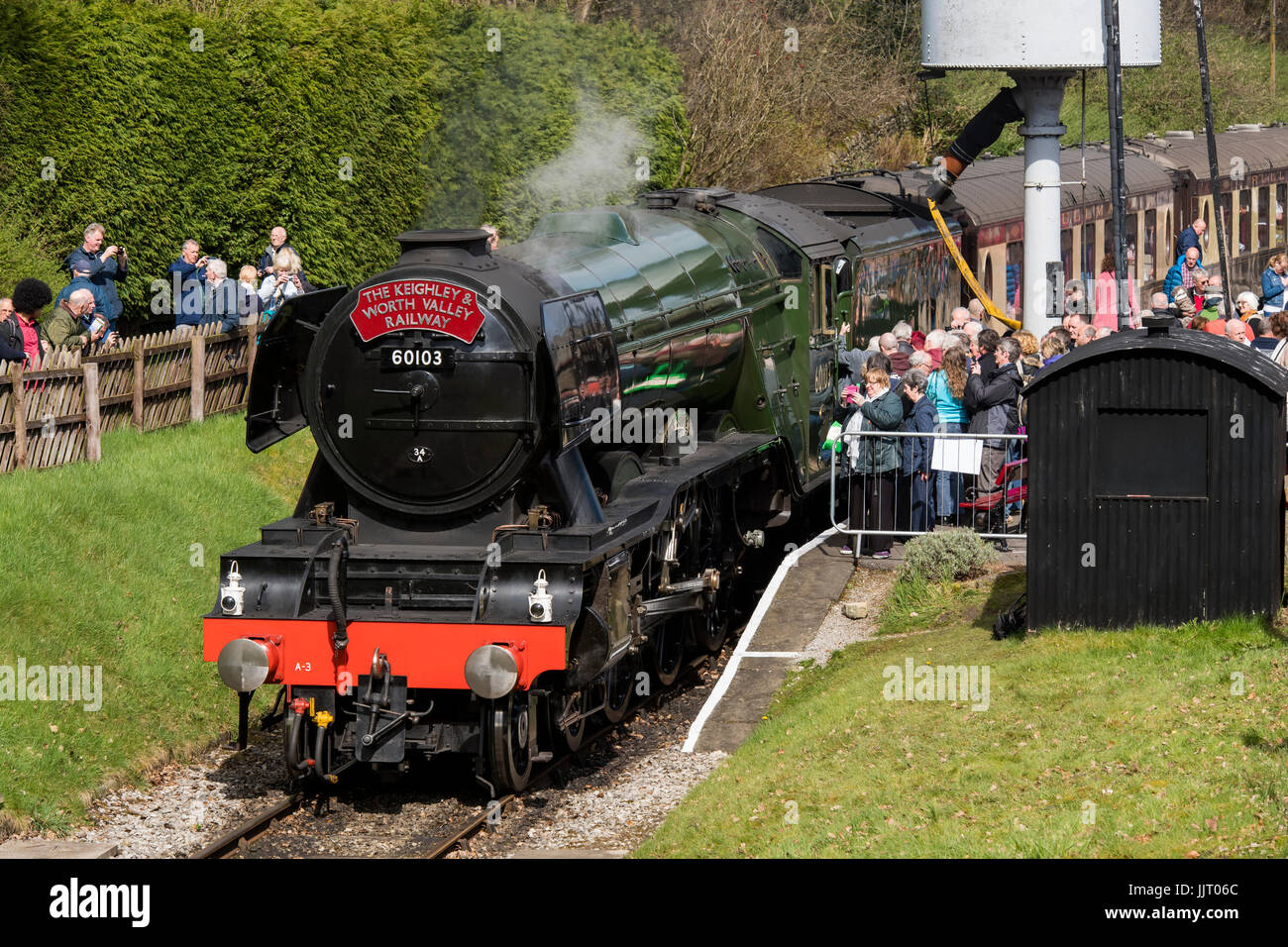 La folla di persone di visualizzare iconico locomotiva a vapore, LNER 60103 Flying Scotsman sbuffando fumo, sulle vie di Keighley e Worth Valley Railway, Inghilterra, Regno Unito. Foto Stock