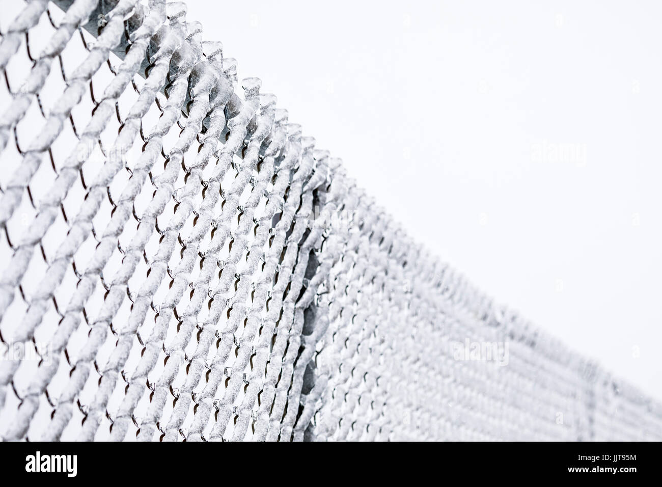 Coperte di ghiaccio catena collegamento recinto. Foto Stock