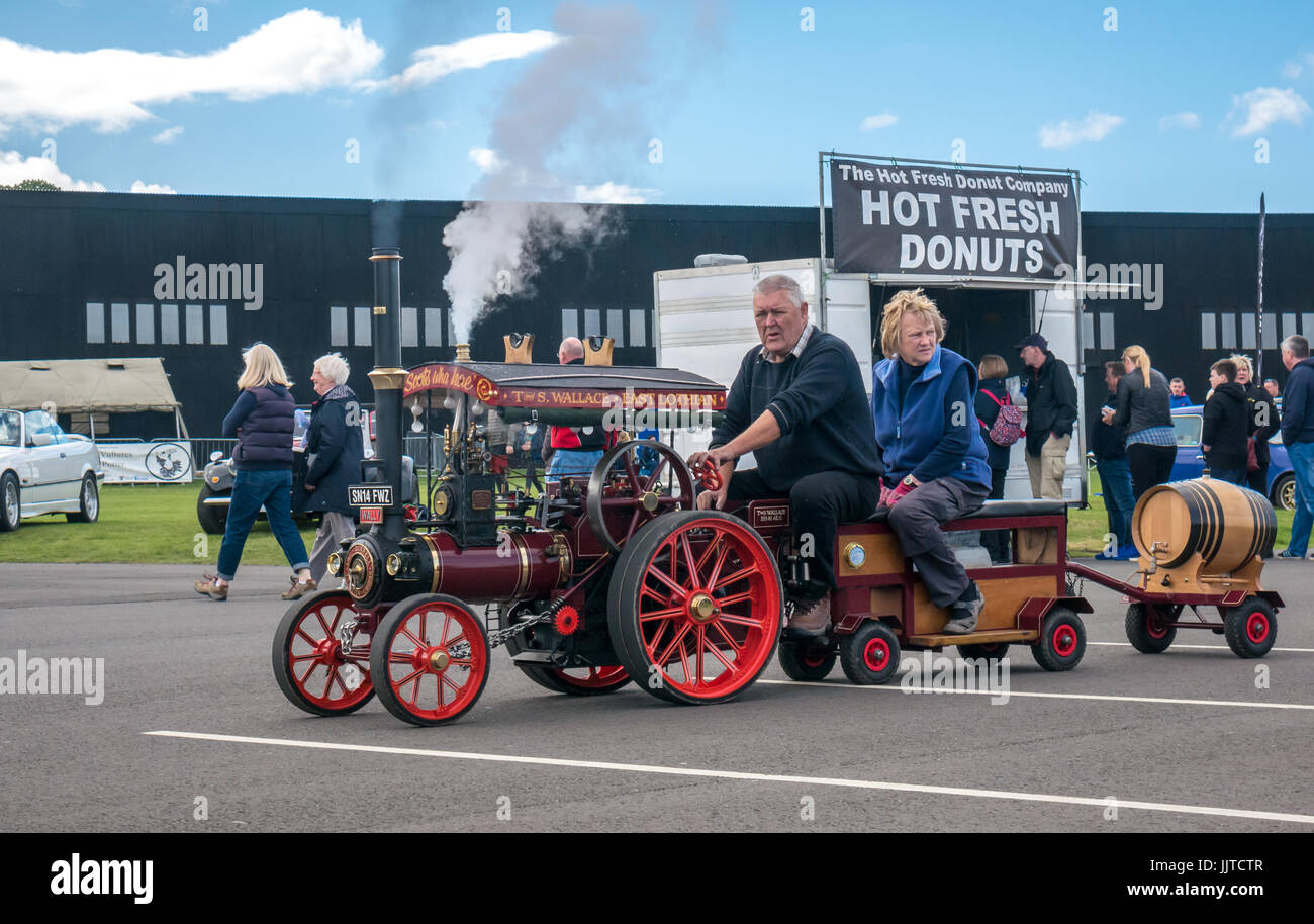 L uomo e la donna sul modello con trazione a vapore il motore denominato T. S. Wallace East Lothian in corrispondenza delle ruote e le ali evento 2016, East Fortune, East Lothian, Scozia, Regno Unito Foto Stock