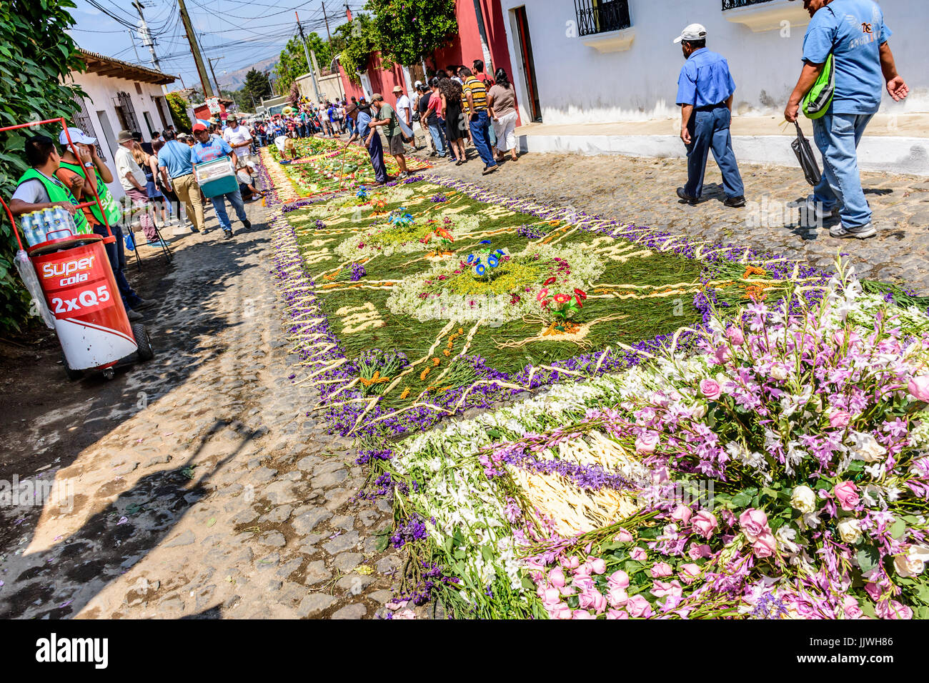Antigua Guatemala - marzo 26, 2017: la gente fa processione tappeti durante la quaresima contro il fondale di acatenango vulcano in città coloniale Foto Stock
