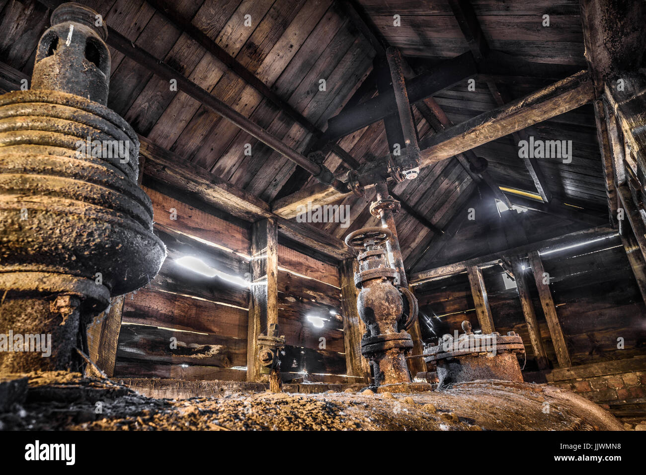 Un vecchio, abbandonata la caldaia a vapore in legno incorniciata capannone. Foto Stock