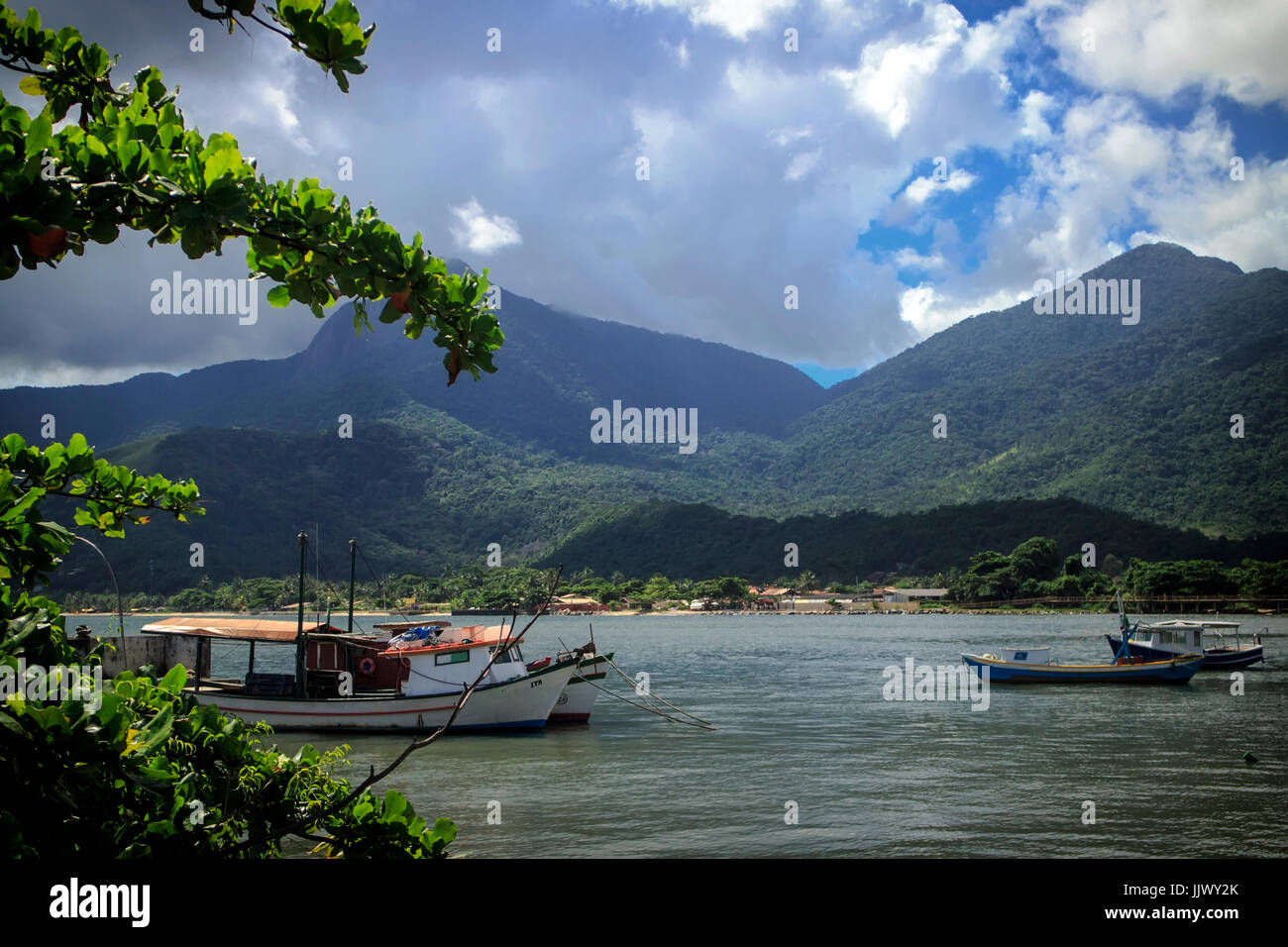 Ilhabela São Paulo, Brasile. Barche in acqua con montagne che incontrano il mare in background. Questa isola è una popolare destinazione turistica. Foto Stock