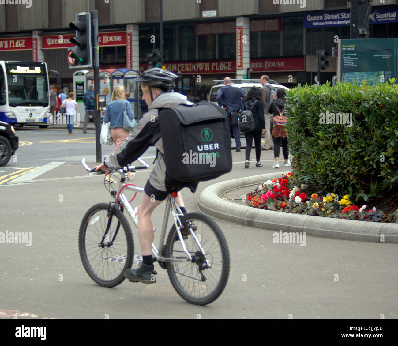 Giovane ragazzo consegna bike ciclista Uber Consegna del cibo offrendo al di fuori sulla strada Foto Stock