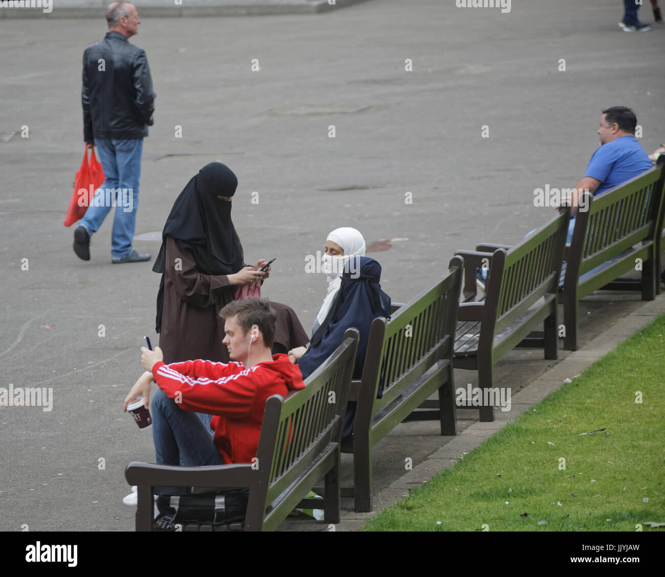 Asian refugee vestito Hijab sciarpa su George Square Glasgow street NEL REGNO UNITO scena quotidiana Foto Stock