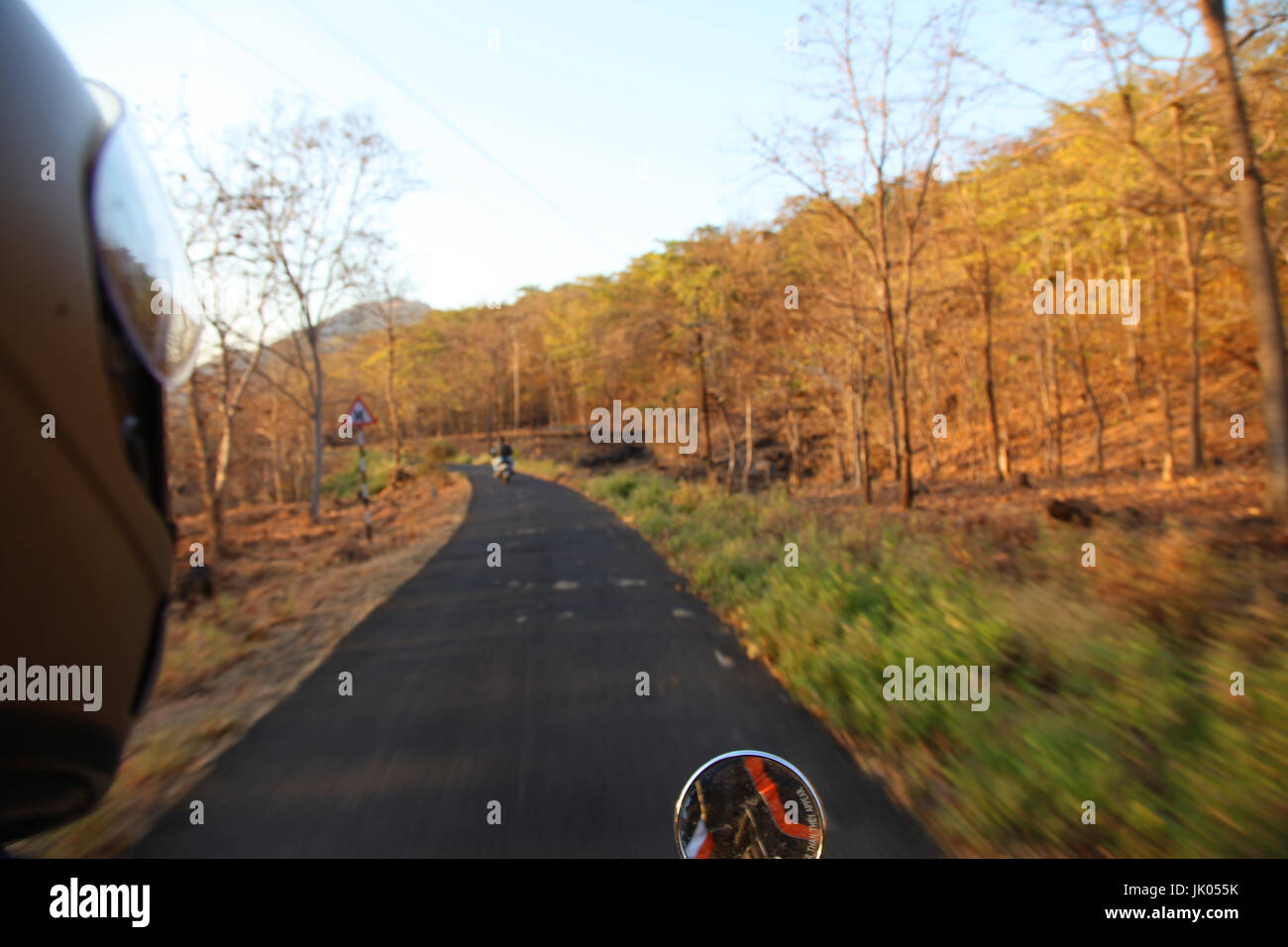 Biker guida di un motociclo lungo la strada asfaltata. Foto Stock