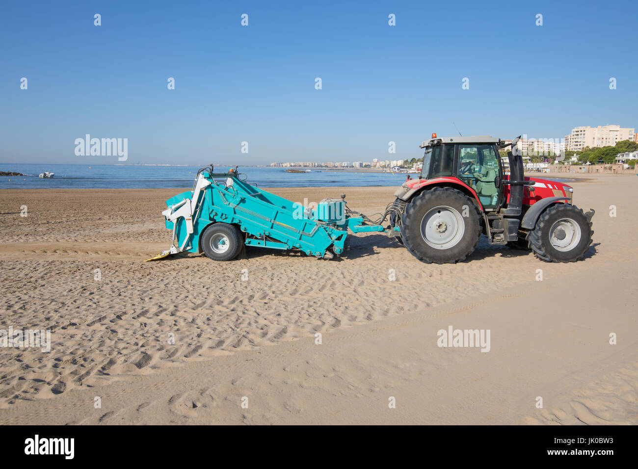 Trattore rosso verde con rimorchio pulizia filtro sabbia della spiaggia Els  Terrers, a Benicassim, Castellon, Valencia, Spagna, Europa. Mare  Mediterraneo Foto stock - Alamy